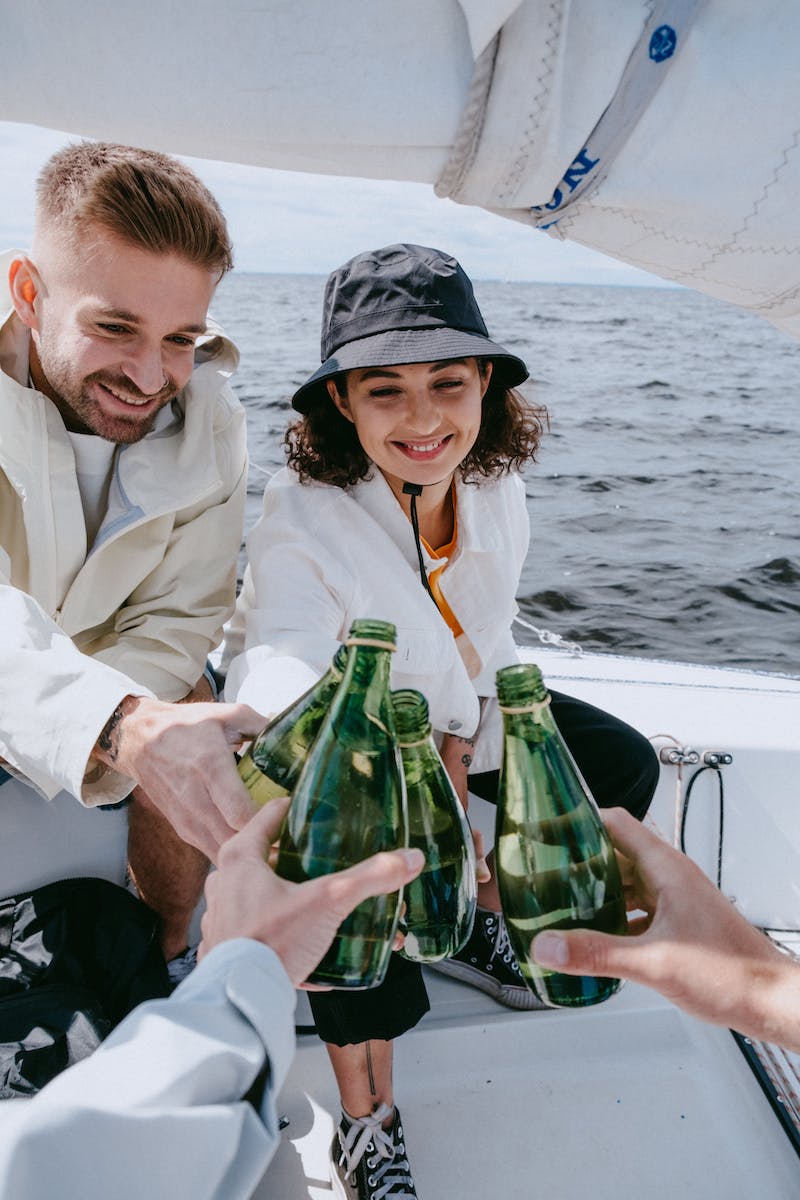 Man in White Dress Shirt Holding Green Glass Bottle