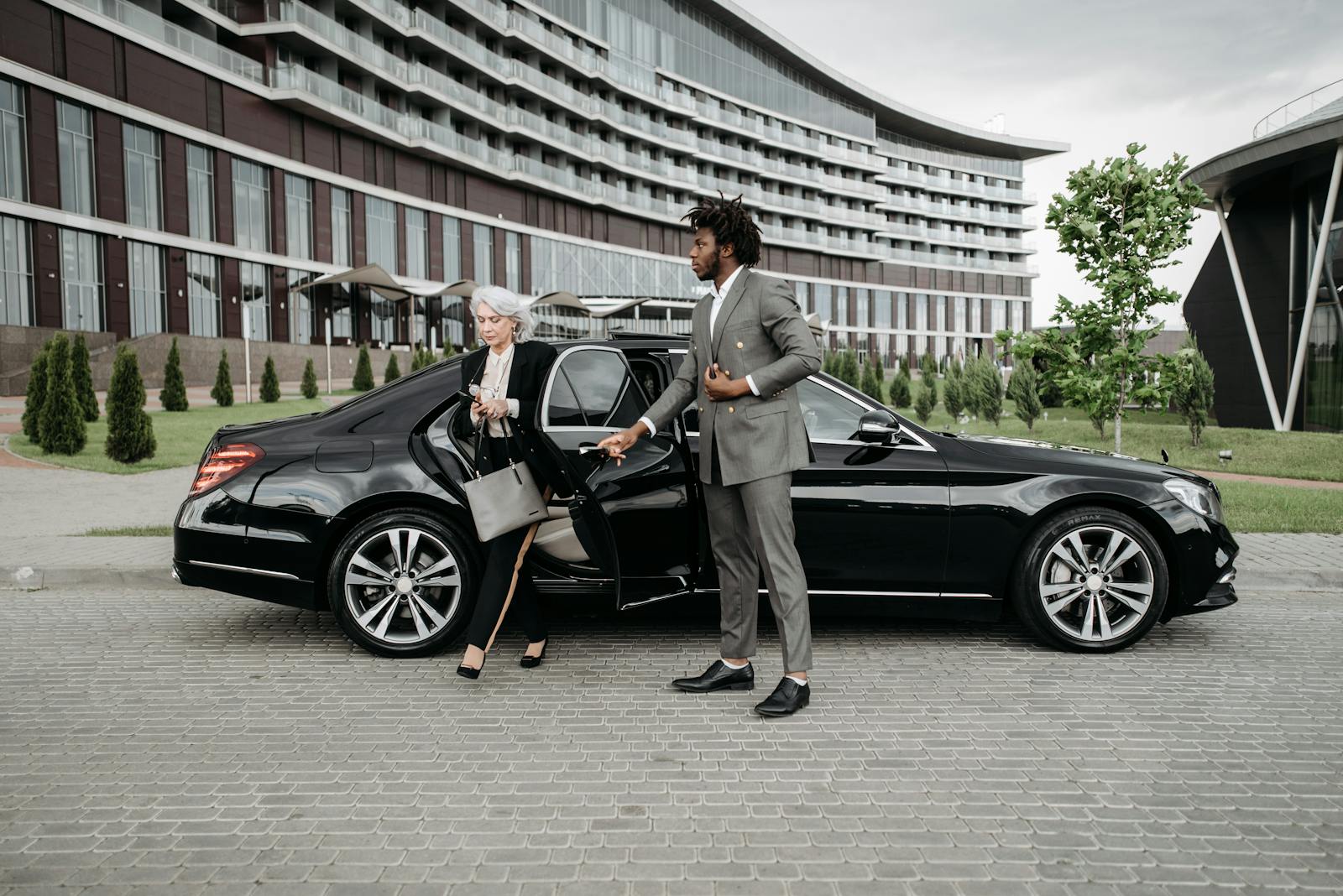 Woman in Black Blazer Standing beside Black Car